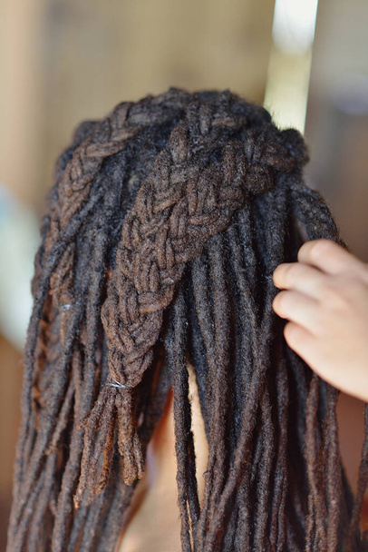 Detalle de las trenzas de una mujer afro peinándose el pelo - Foto, imagen