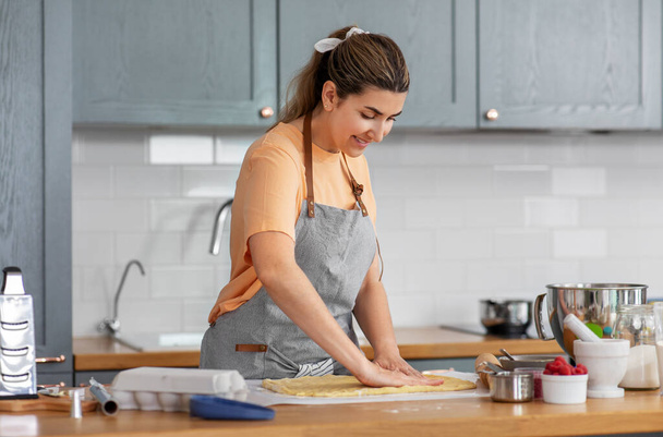 woman cooking food and baking on kitchen at home - Valokuva, kuva