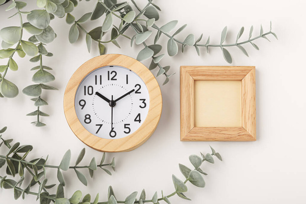 Reloj con marco de madera maqueta con planta de decoración sobre fondo beige - Foto, Imagen