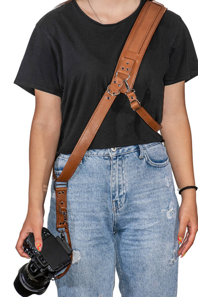 Girl with brown hand made natural leather camera shoulder strap isolated on a white background. Photographer equipment, stylish, vintage, retro feel. Clipping path - Photo, Image
