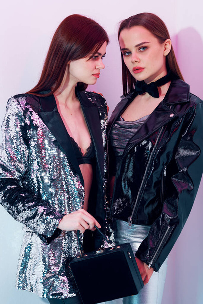 two trendy women in modern style disco clothing - Zdjęcie, obraz