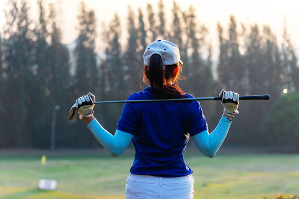Női golfozó A golf klubok segítségével, hogy segítsen csavarni Hogy bemelegítse a testet, mielőtt a játék játék, homályos puha természet háttér, Életmód Concept. Sport koncepció - Fotó, kép