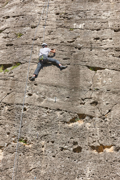 Kiipeilijä graniittiseinällä. Äärimmäistä urheilua. Vuoristoalueiden ulkoilu - Valokuva, kuva
