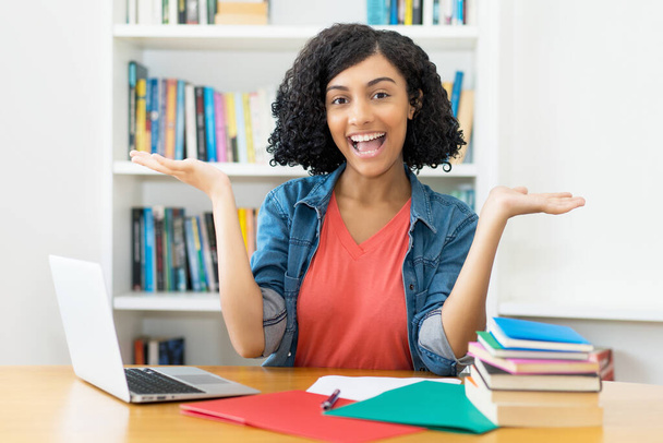 Successful female student - laughing peruvian young adult woman at desk at classroom - Foto, Bild
