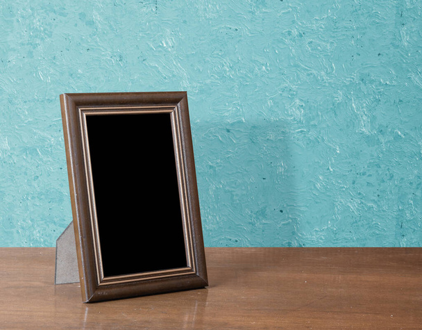 wooden photo frame on table, blue wall - Photo, Image