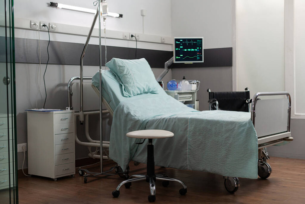 Puste łóżko w pokoju szpitalnym ze sprzętem medycznym - Zdjęcie, obraz