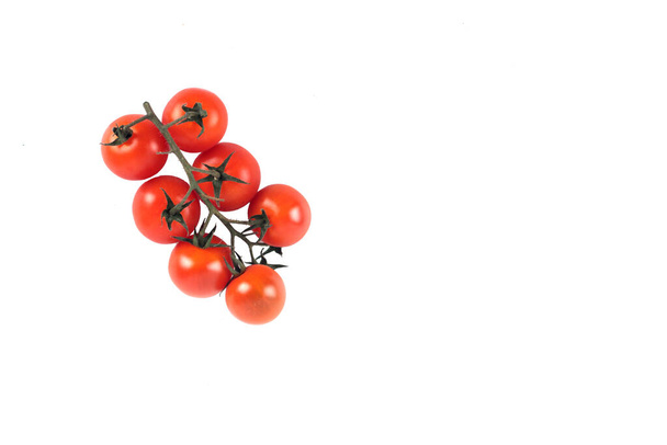 a branch of red Cherry-tomatoes isolated on white background. Image contains copy space - 写真・画像