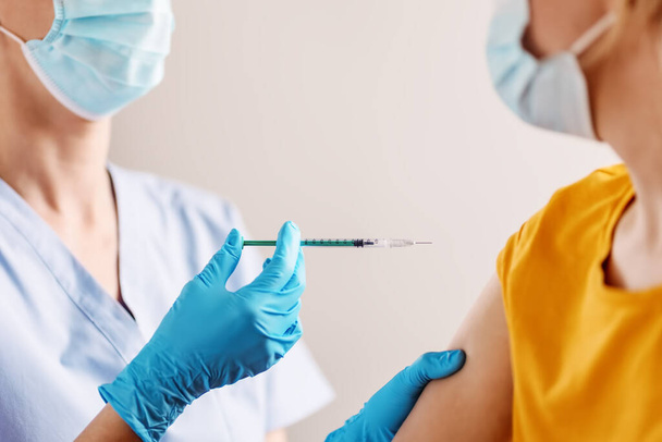 Медсестра дає шприц вакцини проти Ковида 19 пацієнту.. - Фото, зображення