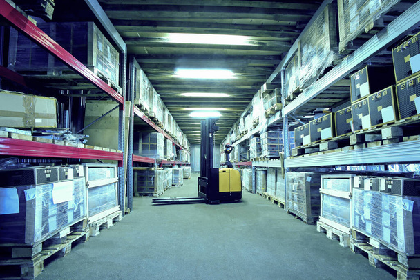 Interior de un almacén industrial con bastidores y montacargas - Foto, Imagen