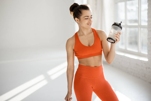 Sports woman with protein shaker at gym - Foto, imagen