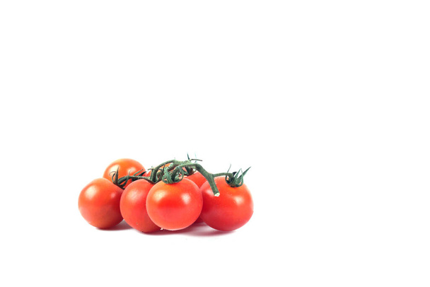 una rama de tomates rojos de cereza aislados sobre fondo blanco. La imagen contiene espacio de copia - Foto, imagen