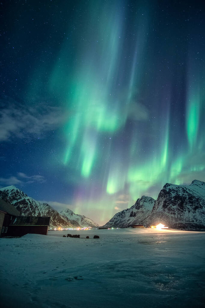 Fantasztikus zöld Aurora borealis, északi fények csillagokkal világít havas hegyen az éjszakai égen télen a Lofoten-szigeteken, Norvégiában - Fotó, kép