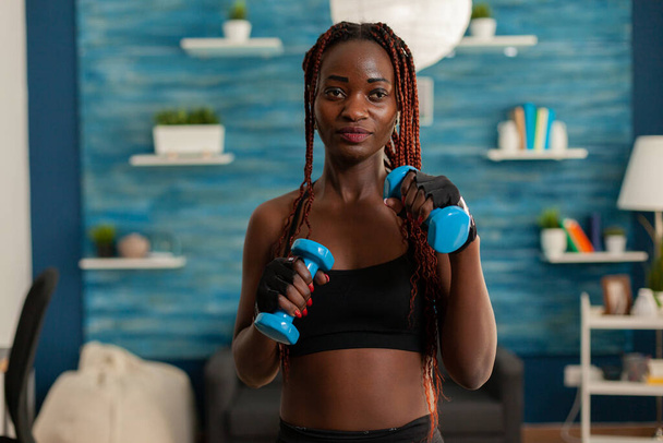 Чорна жінка піклується про тіло, працюючи тренувальні м'язи рук
 - Фото, зображення