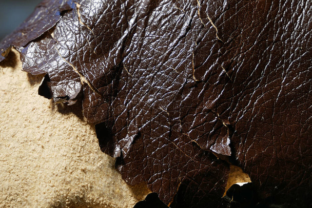 Shabby y desgastado fondo de piel sintética marrón textura con grietas y daños, fondo reparador. Peeling sofá de cuero sintético, primer plano - Foto, Imagen