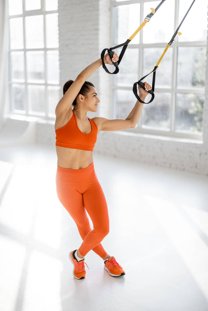 Woman training on TRX fitness straps - Photo, Image