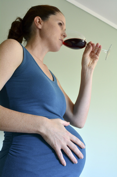 Вагітна жінка п'є червоне вино
 - Фото, зображення