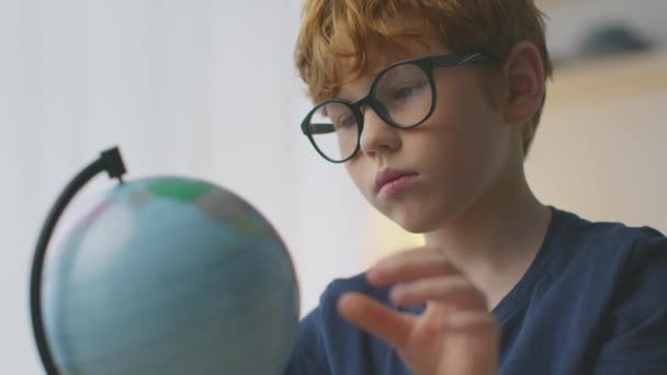 Урок географії. Крупним планом портрет милий маленький рудий хлопчик розмахуючи глобусом, досліджуючи планету і вивчаючи карту світу
 - Кадри, відео