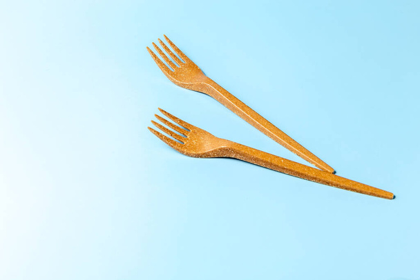 Disposable plastic forks on a blue background. Disposable tableware. Concept. Place for your text. High quality photo - Photo, Image