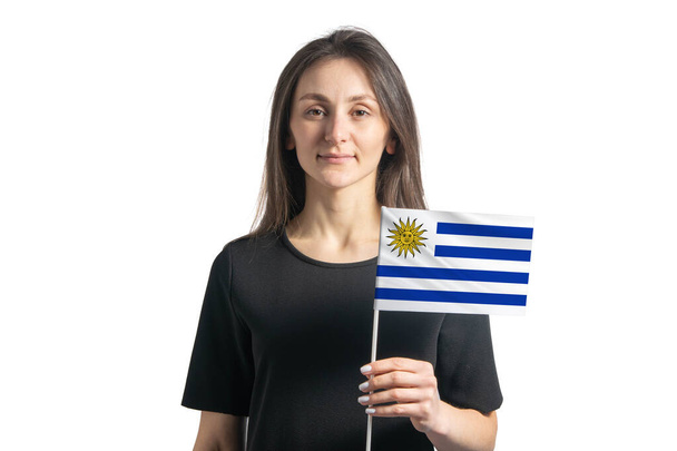 Ευτυχισμένη νεαρή λευκή κοπέλα που κρατά τη σημαία της Ουρουγουάης απομονωμένη σε λευκό φόντο. - Φωτογραφία, εικόνα