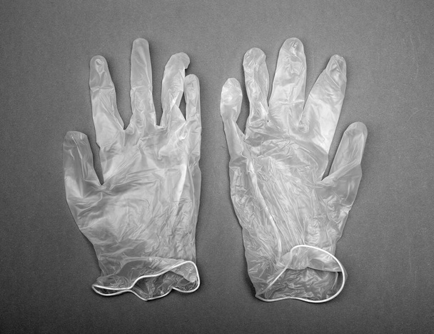 пара одноразовых защитных перчаток на сером фоне - Фото, изображение