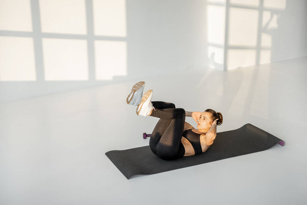 Mulher fazendo fitness no quarto branco sozinho - Foto, Imagem