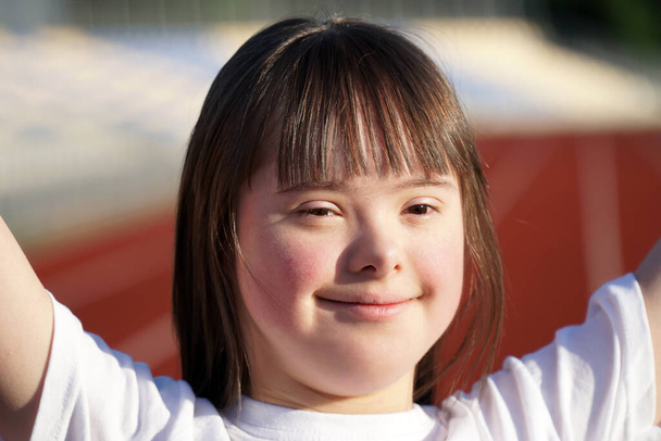 Klein meisje met Down Syndroom op het stadion - Foto, afbeelding
