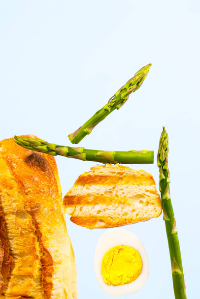 Fresh Grilled Bread, Asparagus and Egg. Ingridients for Breakfast. Equilibrium floating food. Balance levitation Food. Vertical Photo. - Photo, Image