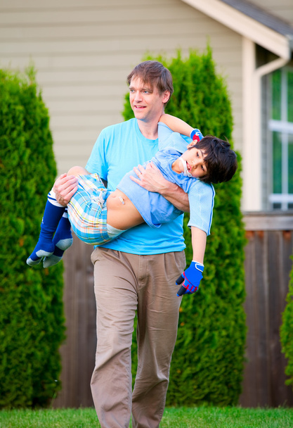 Father carrying disabled son outdoors - Photo, Image