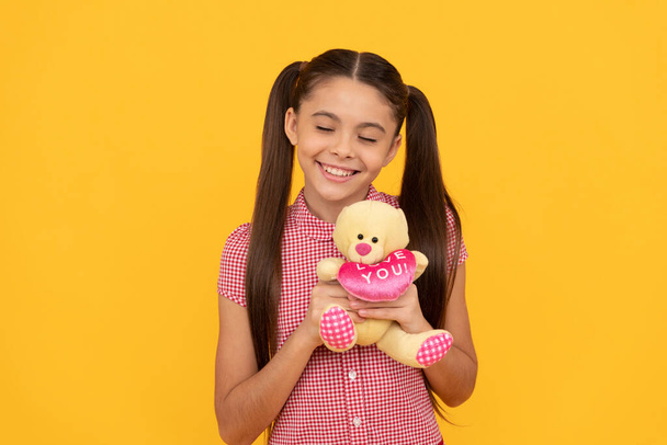 dreamy child hold bear toy gift on yellow background, holiday - Φωτογραφία, εικόνα