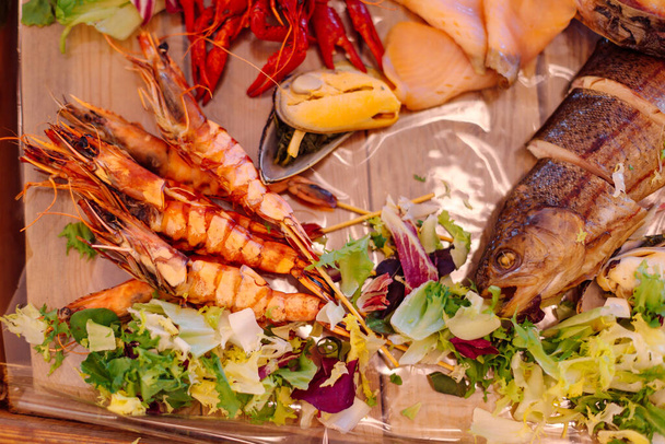 Assortiment de divers fruits de mer, disposés sur un plateau en bois. Buffet de poisson à l'hôtel. Gâterie festive. Cuisine traditionnelle. Repos et voyages.  - Photo, image