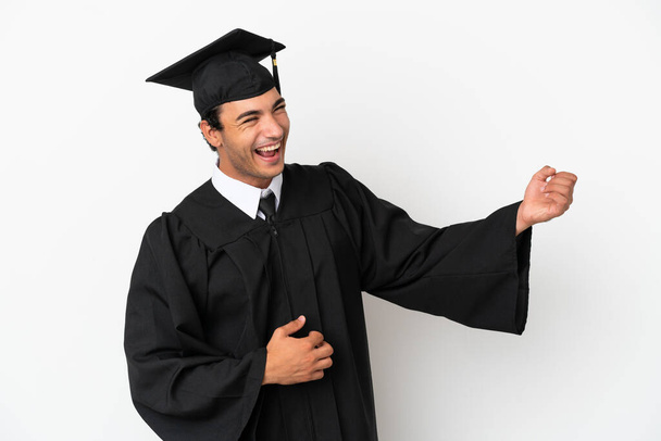 Молодий випускник університету над ізольованим білим фоном робить жест гітари
 - Фото, зображення