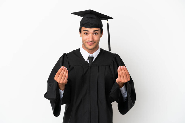 Молодой выпускник университета на изолированном белом фоне зарабатывает деньги жест - Фото, изображение
