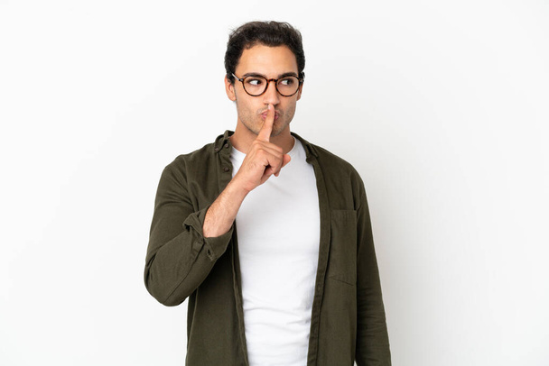 Blanke knappe man over geïsoleerde witte achtergrond met een teken van stilte gebaar steek vinger in de mond - Foto, afbeelding