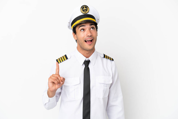 Airplane pilot over isolated white background pointing up and surprised - Fotoğraf, Görsel