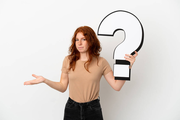 Teenager zrzka dívka izolované na bílém pozadí drží ikonu otazník a mají pochybnosti - Fotografie, Obrázek