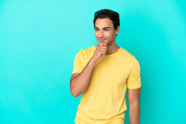 Caucasian handsome man over isolated blue background looking to the side and smiling - Foto, immagini