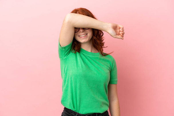 Teenager redhead girl over isolated pink background covering eyes by hands - Фото, изображение
