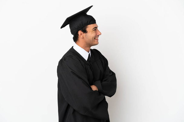 Graduado universitario joven sobre fondo blanco aislado en posición lateral - Foto, imagen