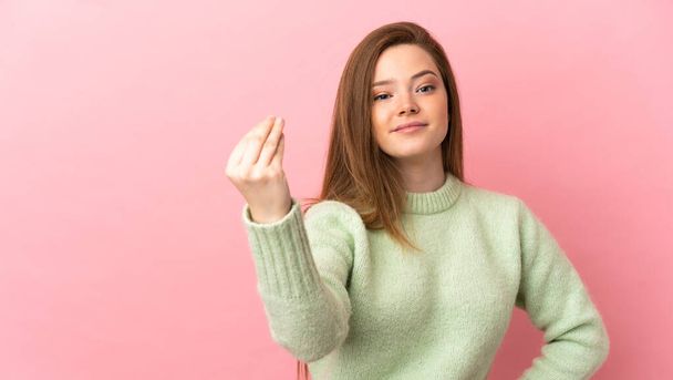 Teenager Mädchen über isoliertem rosa Hintergrund macht italienische Geste - Foto, Bild