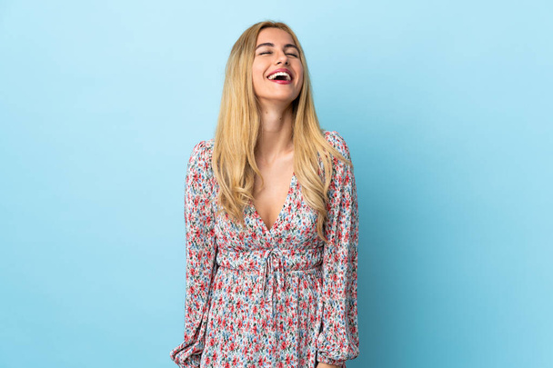 Young Uruguayan blonde woman over isolated blue background laughing - Photo, image