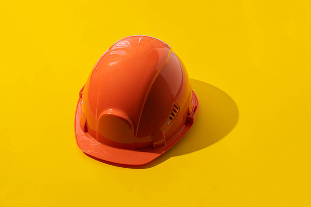 シンプルなオレンジのヘルメットと抽象的でミニマリズム的な安全性の概念は - 写真・画像