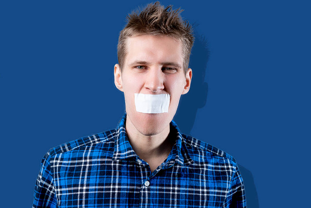 ein Mann mit Klebeband schließt den Mund, hört auf zu reden und schaltet ab, Zensurkonzept, - Foto, Bild
