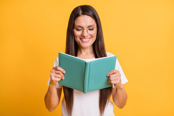 Photo of happy charming young woman hold read book good mood isolated on vibrant yellow color background - Φωτογραφία, εικόνα