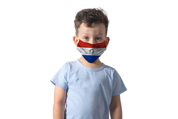 Légzőkészülék Paraguay zászlajával. Fehér fiú tesz orvosi arc maszk elszigetelt fehér háttér. - Fotó, kép
