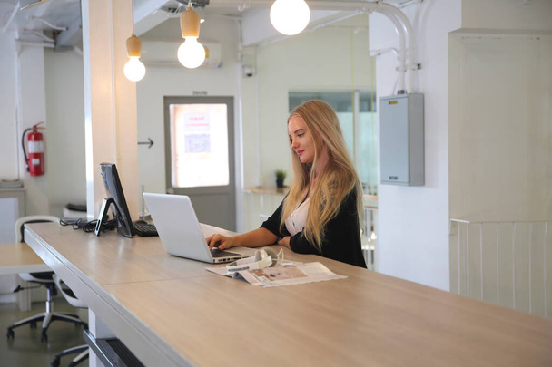 La donna sorridente che utilizza laptop sul posto di lavoro per le piccole imprese che cercano di coinvolgere il pubblico e la creazione di contenuti in scala può adottare nuove tecnologie di marketing nello spazio di lavoro. Concetto freelance. - Foto, immagini