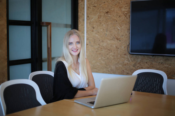 Χαμογελαστή γυναίκα που χρησιμοποιεί φορητό υπολογιστή στο χώρο εργασίας για τις μικρές επιχειρήσεις που αναζητούν να συμμετάσχουν το κοινό και τη δημιουργία περιεχομένου κλίμακας μπορεί να υιοθετήσει νέα τεχνολογία μάρκετινγκ στο χώρο εργασίας. Έννοια freelancer. - Φωτογραφία, εικόνα