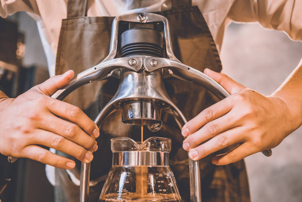 professionelle Barista macht Heißgetränk Espresso schwarzer Kaffee auf Vintage-Holztisch Slow Bar im Café, brauen Koffein in eine Glasschale am Morgen, Filtertropfengetränk Kaffee Stil, Hipster-Lifestyle - Foto, Bild