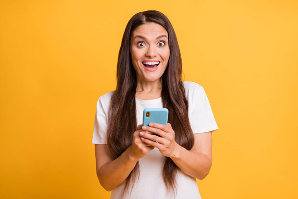 Photo portrait of female blogger commenting browsing internet smiling happy isolated on vibrant yellow color background - Fotó, kép