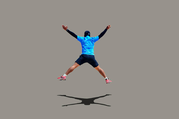 Man springen met armen en benen verspreiden vrolijk op gekleurde achtergrond met clipping pad - Foto, afbeelding