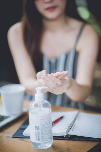 an asian young women using alcohol gel washing her hands to prevent corona virus covid-19, hand sanitizer, parademic concept, selfcare, disease, infection, protection, covid-19 safety guideline. - Photo, image